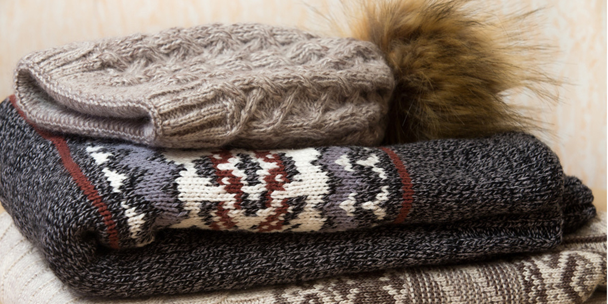 a winter hat and sweater folded in a neat pile