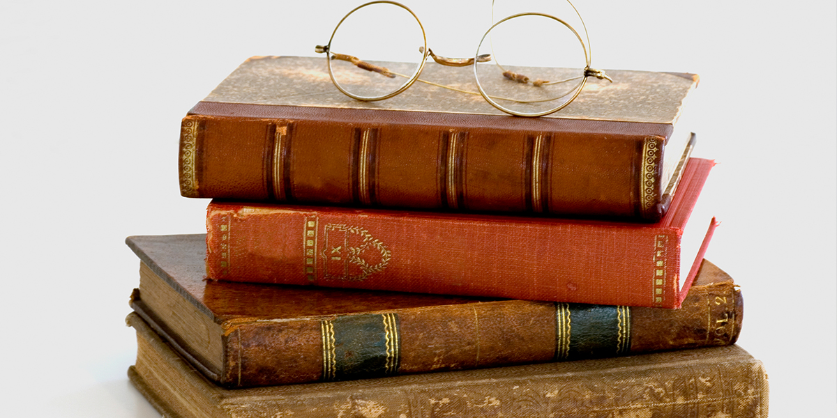 a stack of books with glasses on top of the stack